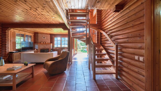 A log cabin interior with a spiral staircase, a fireplace, a television, and a dining area. - Beach & Golf Retreat W Amazing Pool, By Timecooler (Almada)