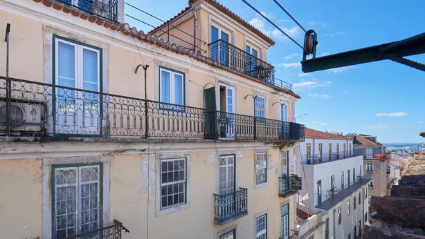 Un edificio de varios pisos con balcones, ventanas y cielo despejado.