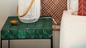 A room with a bed, a woven basket, a bowl, and a green patterned table. - Seaview & Sunset Balcony Charm, By Timecooler (Setubal)