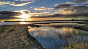 A calm body of water reflecting the sky, with a distant shoreline and a sunset. - 4 Star Holiday Home in Ronde (Ronde)