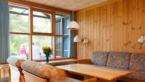 A wooden cabin interior with a bench, sofa, and table. - 6 Person Holiday Home in Vaeggerlose (Vaeggerlose)