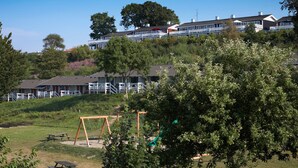 Un quartiere residenziale con case, un’area giochi e tavoli da picnic.