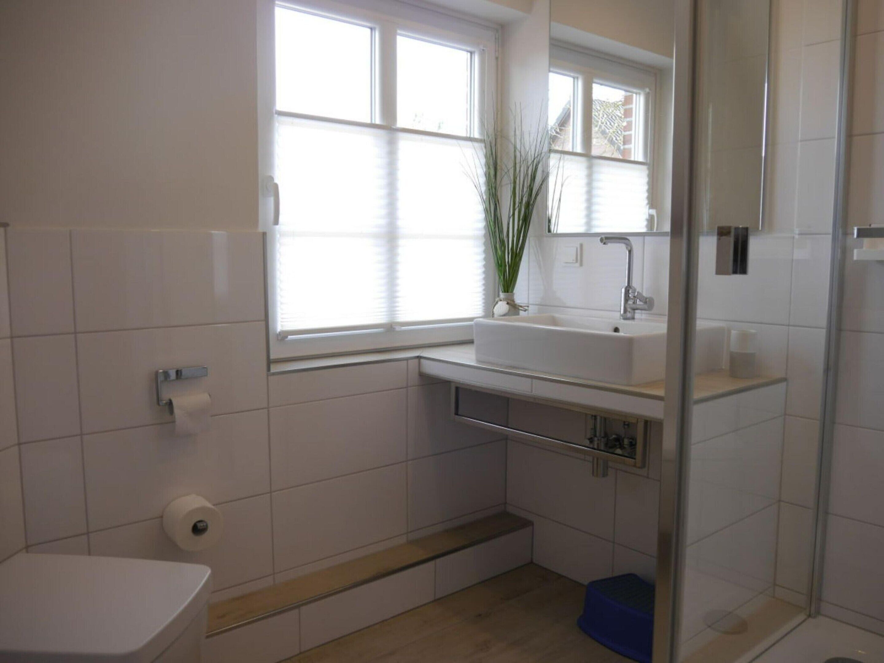 Un bagno moderno con lavandino bianco, servizi igienici e zona doccia.