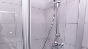 A modern shower with a glass door, a handheld showerhead, and a wall-mounted faucet. - Kürzlich Renovierte 3-bett-ferienwohnung mit Garten und Blick auf den Gletscher (Kaprun)