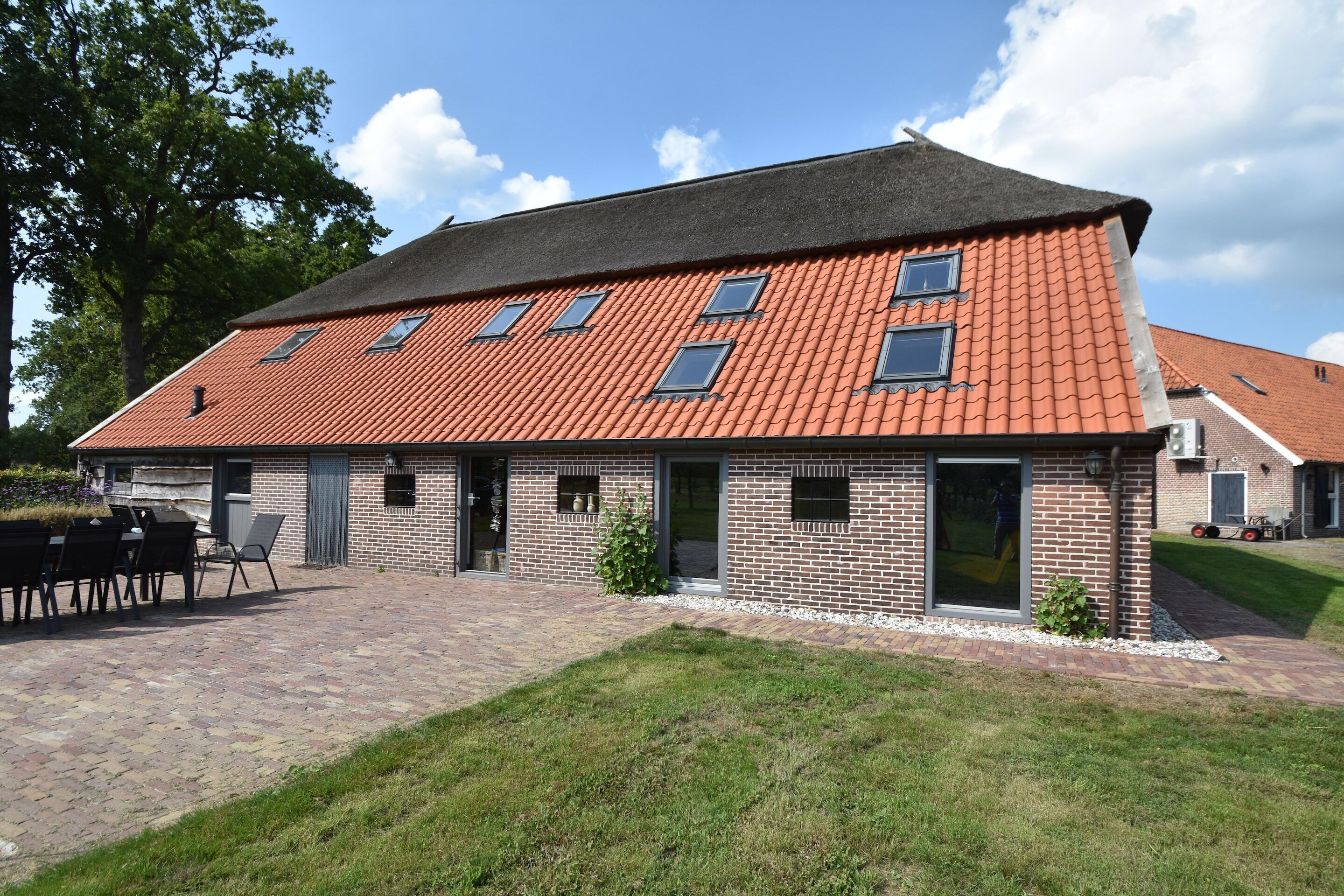 A two-story brick building with a tiled roof and multiple windows.