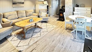 A cozy living room with a sofa, coffee table, and a fireplace. - 6 Person Holiday Home in Hornnes (Evje)