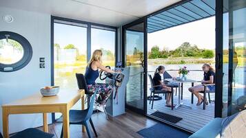A modern interior with a dining area, a control station, and a view of the outdoors.