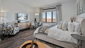 Une chambre à coucher moderne avec un grand lit, un bureau et une chaise.
