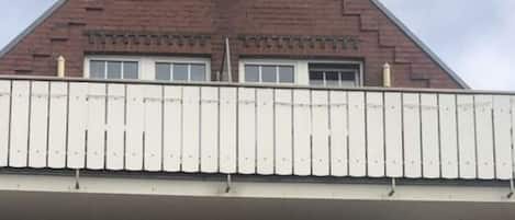 A building with a sign reading "Nordesgrill" and "Krombacher" on the balcony.