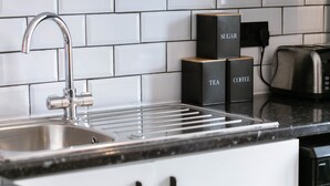 A kitchen with a stainless steel sink, a black countertop, and a toaster. - A perfect base for exploring and relaxing, for work and leisure. Pets welcome. (Exeter)