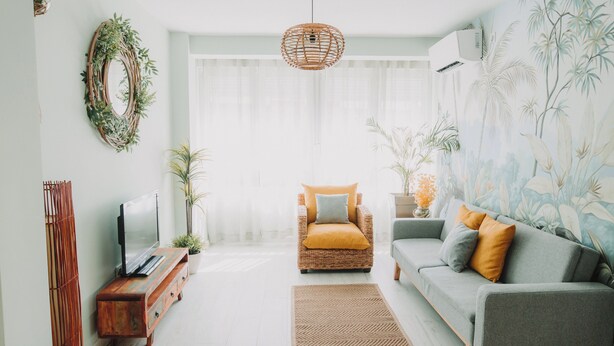 Ein Wohnzimmer mit Fernseher, Sofa und Sessel.