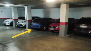 Eine Parkgarage mit mehreren Autos unter Betonpfeilern.