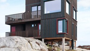 A modern multi-story building with a balcony and large windows. - 6 Person Holiday Home in Sondeled (Risør)