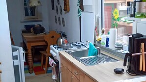 A compact kitchen with a gas stove, sink, and a coffee maker. - Beautiful Querbach hut With Spring Water (Konigsee)