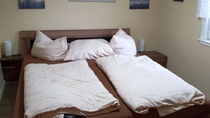 A neatly made bed with white linens, a wooden headboard, and three bedside tables with lamps. - Beautiful Querbach hut With Spring Water (Konigsee)