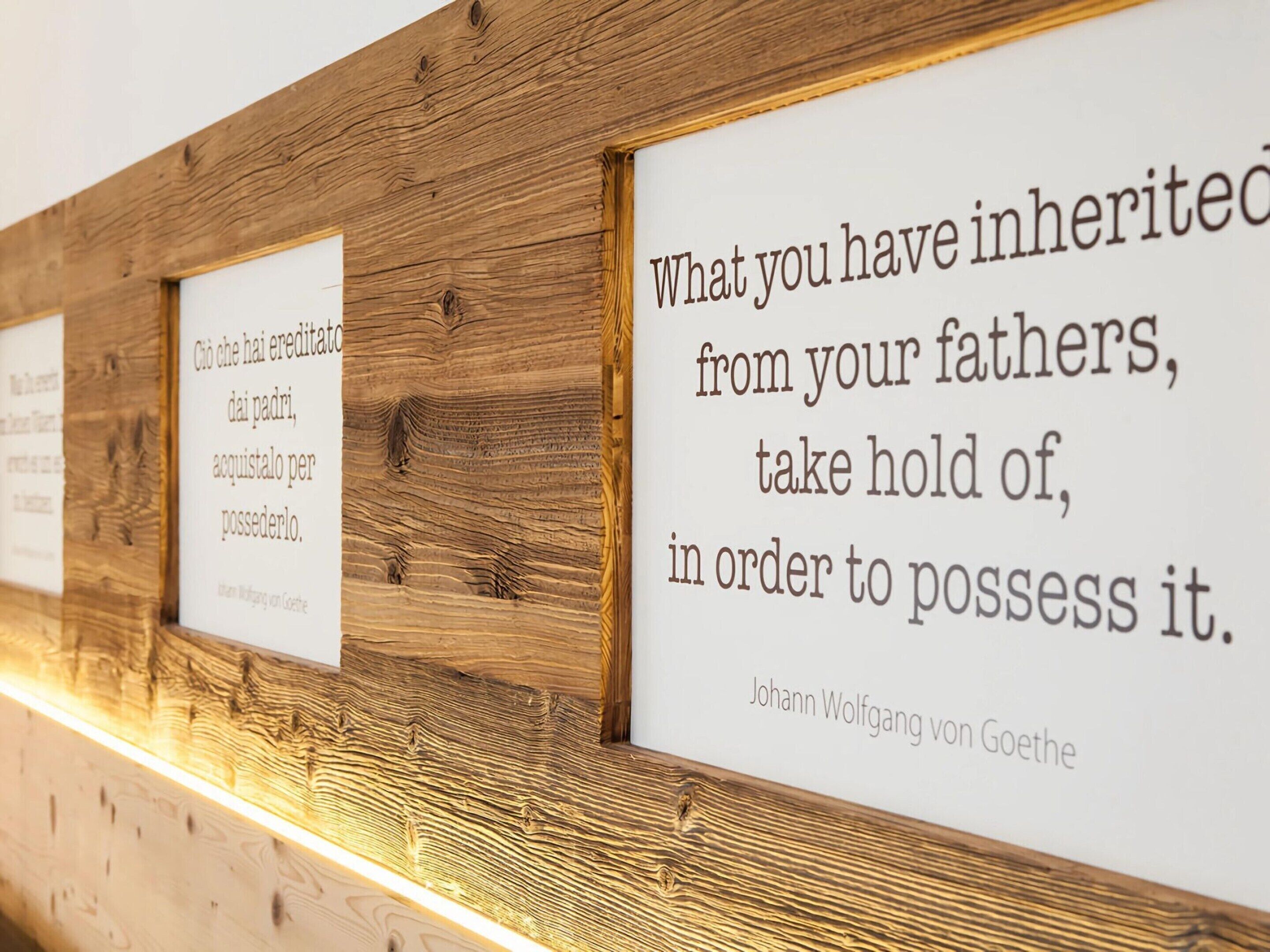 A wooden wall with framed quotes.