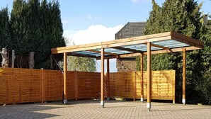 A covered outdoor area with a wooden fence and a brick floor. - Pleasant Apartment in Xanten (Xanten)