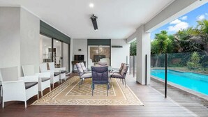 Un amplio espacio exterior con piscina, mobiliario y vistas al entorno.
