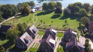 Een overzicht vanuit de lucht van een woongebied met huizen, een meer en een brug.