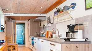A modern kitchen with white cabinetry, a built-in oven, and a coffee machine. - 6 Person Holiday Home in Orsted (Ørsted)