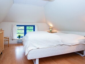 A bedroom with a bed, a window with curtains, a bedside lamp, and a wooden chair. - 6 Person Holiday Home in Orsted (Ørsted)