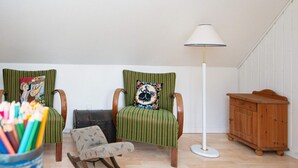 A room with two green upholstered chairs, a small wooden cabinet, and a floor lamp. - 6 Person Holiday Home in Orsted (Ørsted)