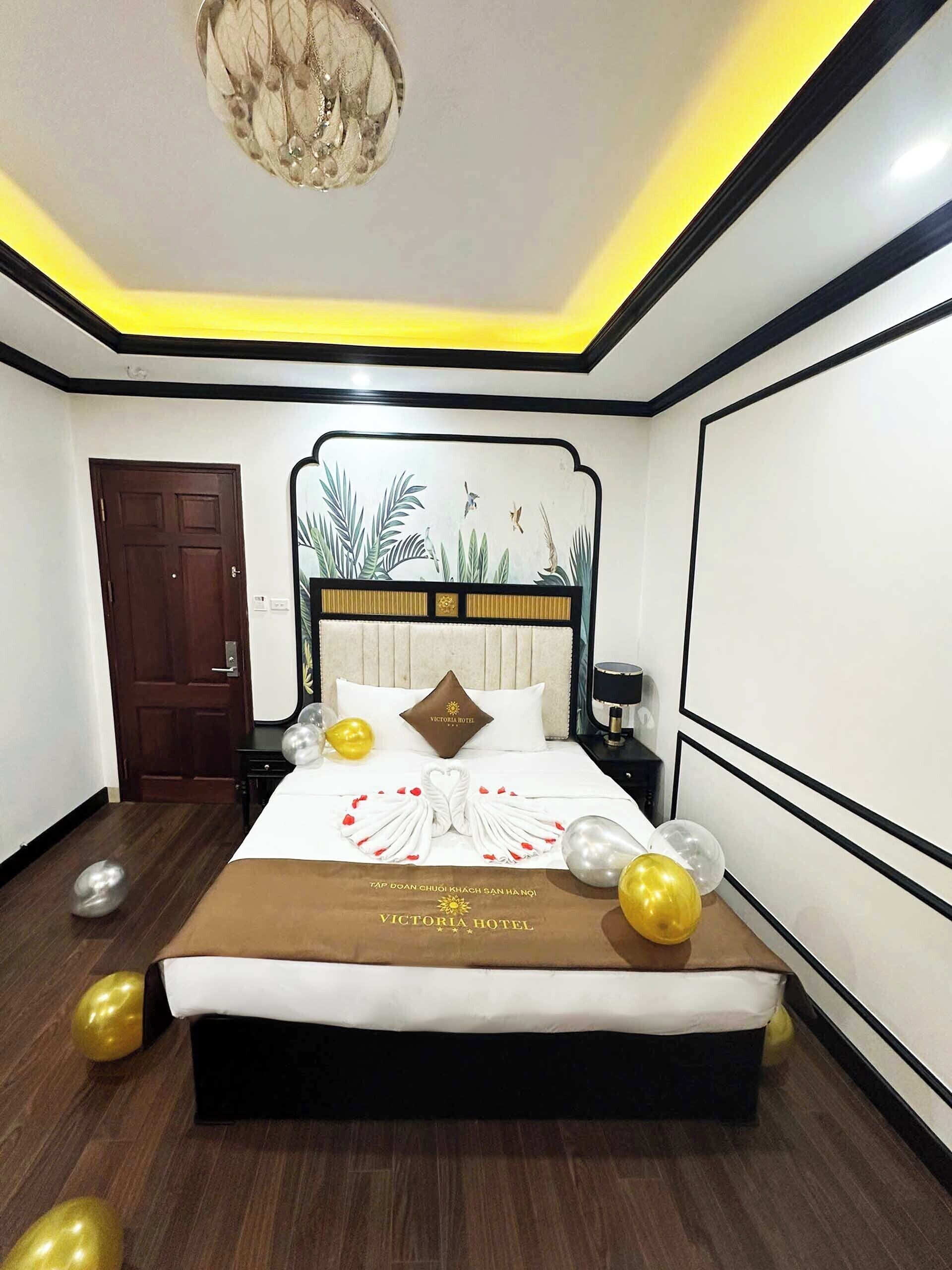 A hotel room with a bed, a nightstand, a lamp, and a door.