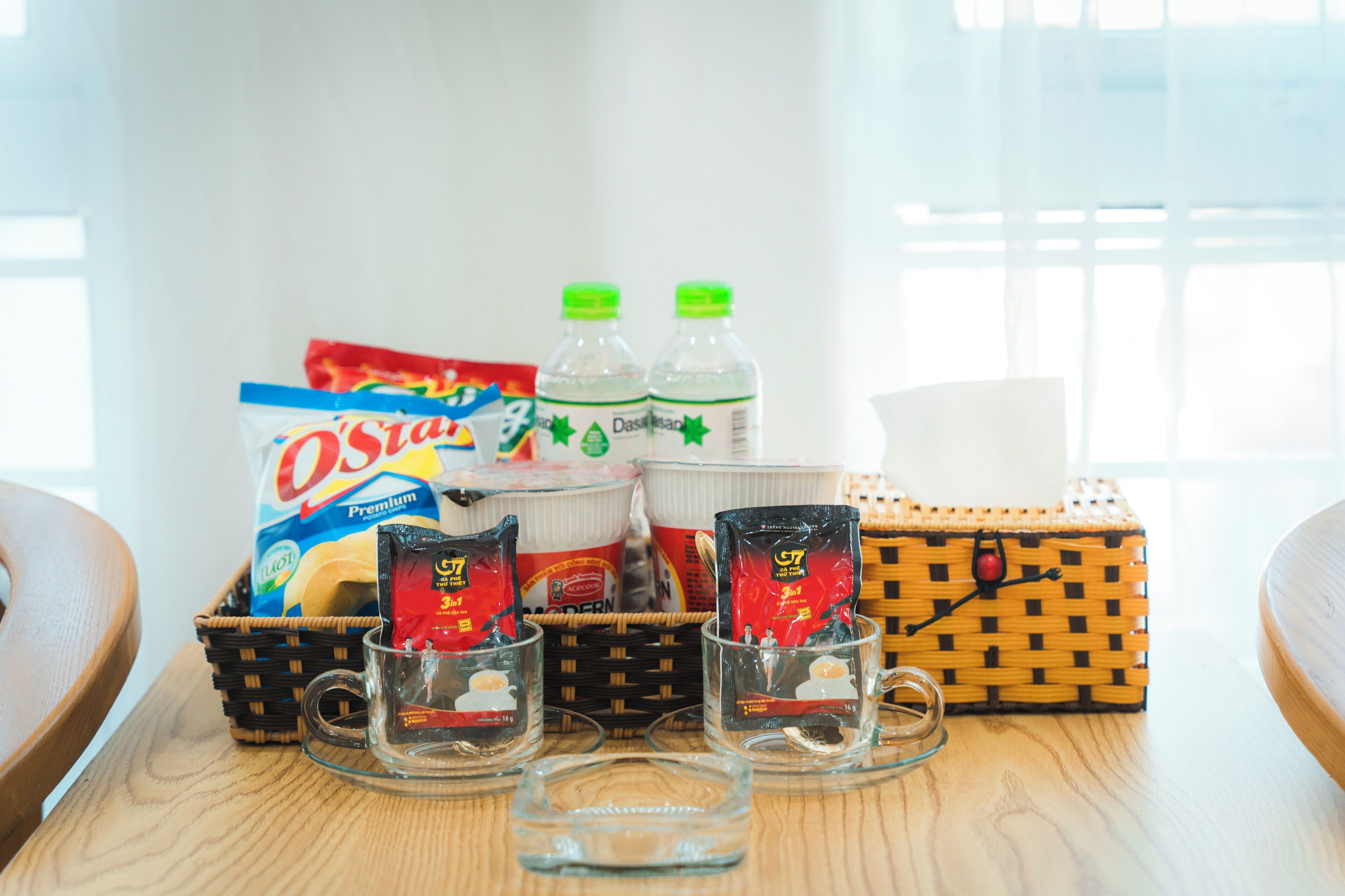 A table with snacks, bottled water, and a basket.