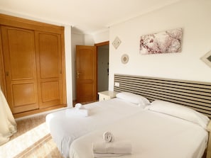 Une chambre d’hôtel avec un grand lit, une armoire en bois et un tableau au mur.