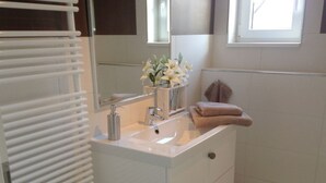 A bathroom with a white sink, mirror, and towel rack. - Holiday Apartment Schliekieker (Kappeln)