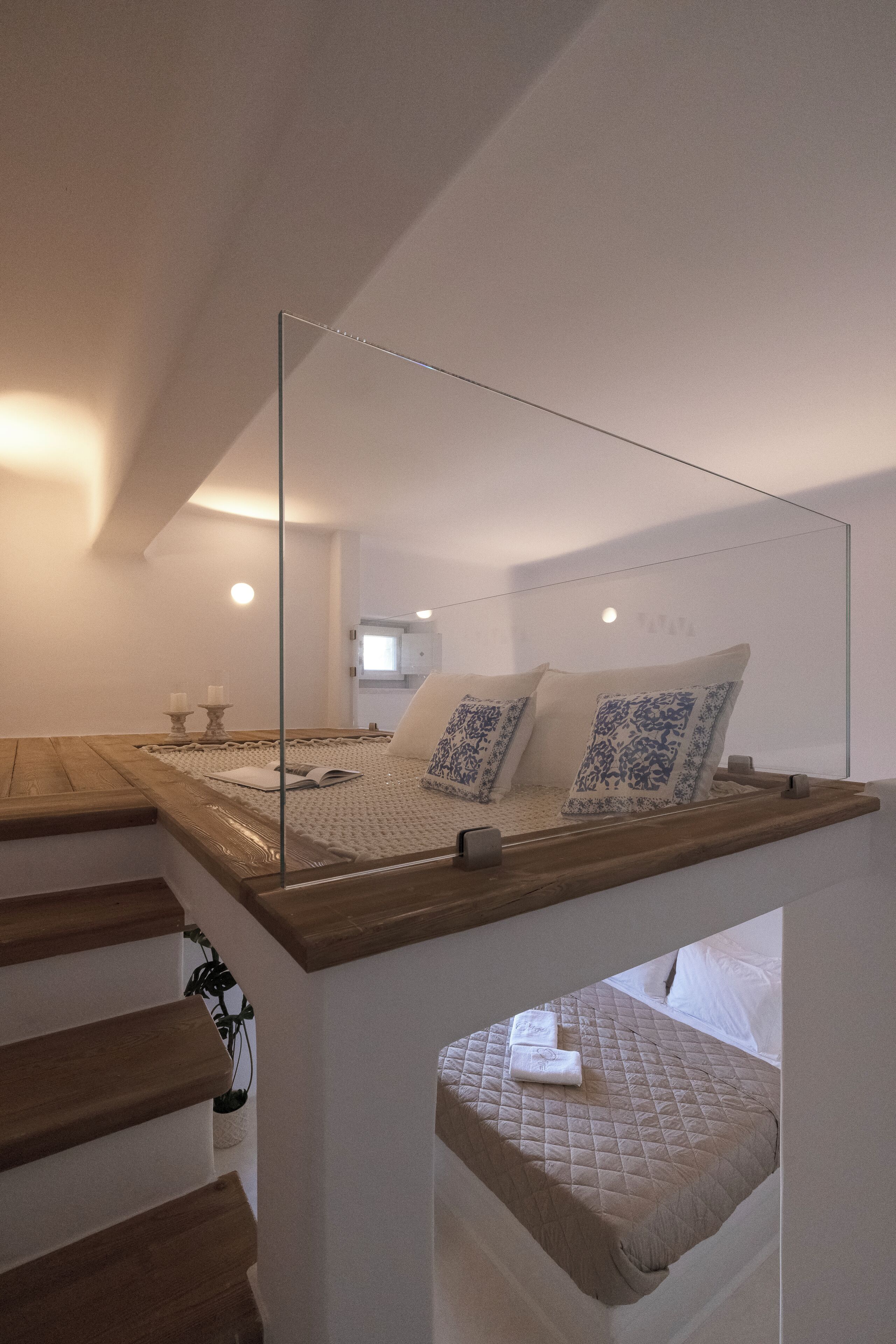 A bedroom with a bed, a mirror, and a staircase.
