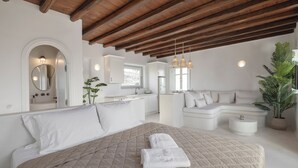 Un dormitorio moderno con una cama grande, un sofá y una zona de cocina.
