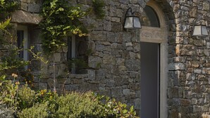 Un edificio de piedra con una puerta y dos luces fijadas a la pared.