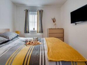 Enjoy a comfortable stay in this stylish room with a neatly made bed, flat-screen TV, and convenient breakfast setup.