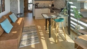 A modern loft-style apartment with a spacious living area, a kitchen, and a glass staircase. - SIGMA Suites Hotel (Neapoli-Sykies)