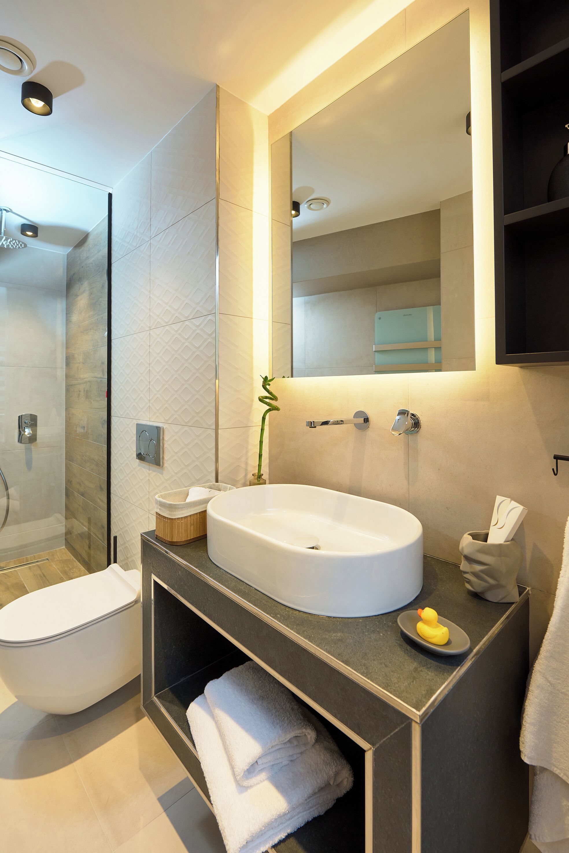 Un baño moderno con un lavamanos grande, inodoro y ducha.