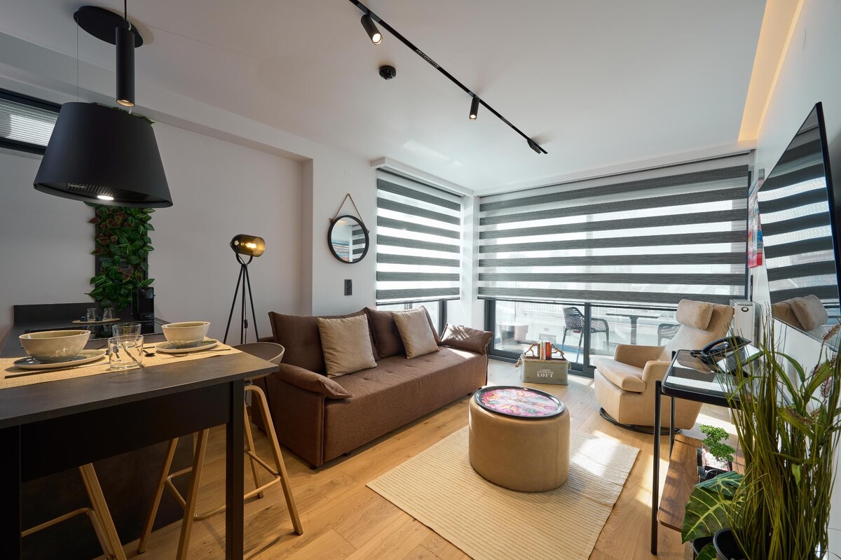 A modern living room with a sofa, coffee table, and dining area.