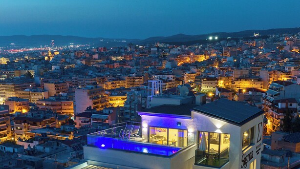 A modern multi-story hotel with a rooftop pool, balconies, and a city view. - SIGMA Suites Hotel (Neapoli-Sykies)