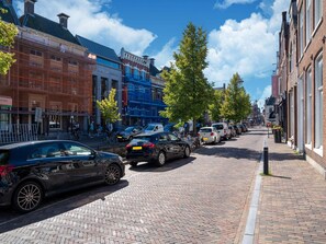 A cobblestone street lined with historic buildings, parked cars, and trees. - Renovated Apartment in the Center of Sneek (Sneek)