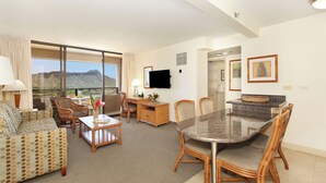 A hotel room with a dining area, a sofa, a TV, and a view of the mountains. - Ocean & Diamond Head Views! Full Kitchen, Lanai, FREE Parking, Wi-Fi & TV! (Honolulu)