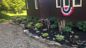 Una casa con un jardín que incluye plantas variadas y un adorno de guirnalda.