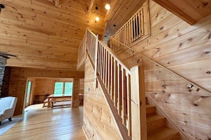 Un intérieur en bois avec un escalier, des murs en bois et un banc.