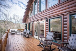 A wooden cabin with a deck, rocking chairs, and large windows. - Our Mountain Retreat (Lake Lure)