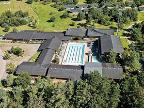 Une vue aérienne d’un quartier résidentiel avec de nombreuses maisons, une piscine et un grand espace vert.