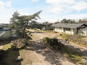A campground with multiple cabins, a dirt path, and surrounding vegetation. - 6 Person Holiday Park Home in Gilleleje (Gilleleje)