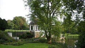 A tranquil park with a gazebo, a pond, and lush greenery. - Apartment in Tisens (Putbus)
