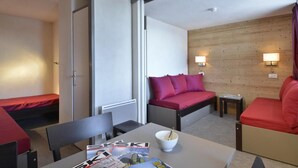 A compact hotel room with a bed, a small table with a bowl, a chair, and a sofa. - Ski-in/ski-out & foot of the slopes, 3rd floor, tv, 28m², La Plagne (La Plagne)