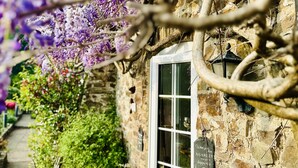 A stone building with a window and a sign that reads "When you man a garden, you grow happiness." - Charming Holiday Cottage in Devon - Country Views (Tiverton)