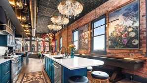 Una cocina moderna con una isla grande, armarios azules y una alfombra decorativa.