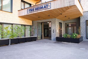 A modern building with a wooden facade and a sign reading "THE HEIMAT".